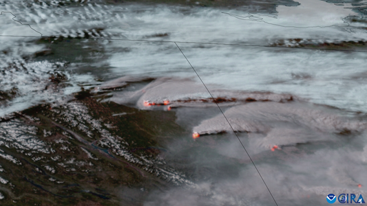 Satellite view of wildfires across British Columbia and Alberta; wide contextual image.