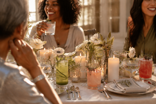 An elegant alcohol-free celebration table with botanical mocktails, candles, flowers, and a warm sophisticated atmosphere.