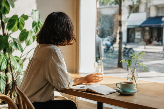 Adult enjoying sparkling water in a bright cafe while choosing an alcohol-free life