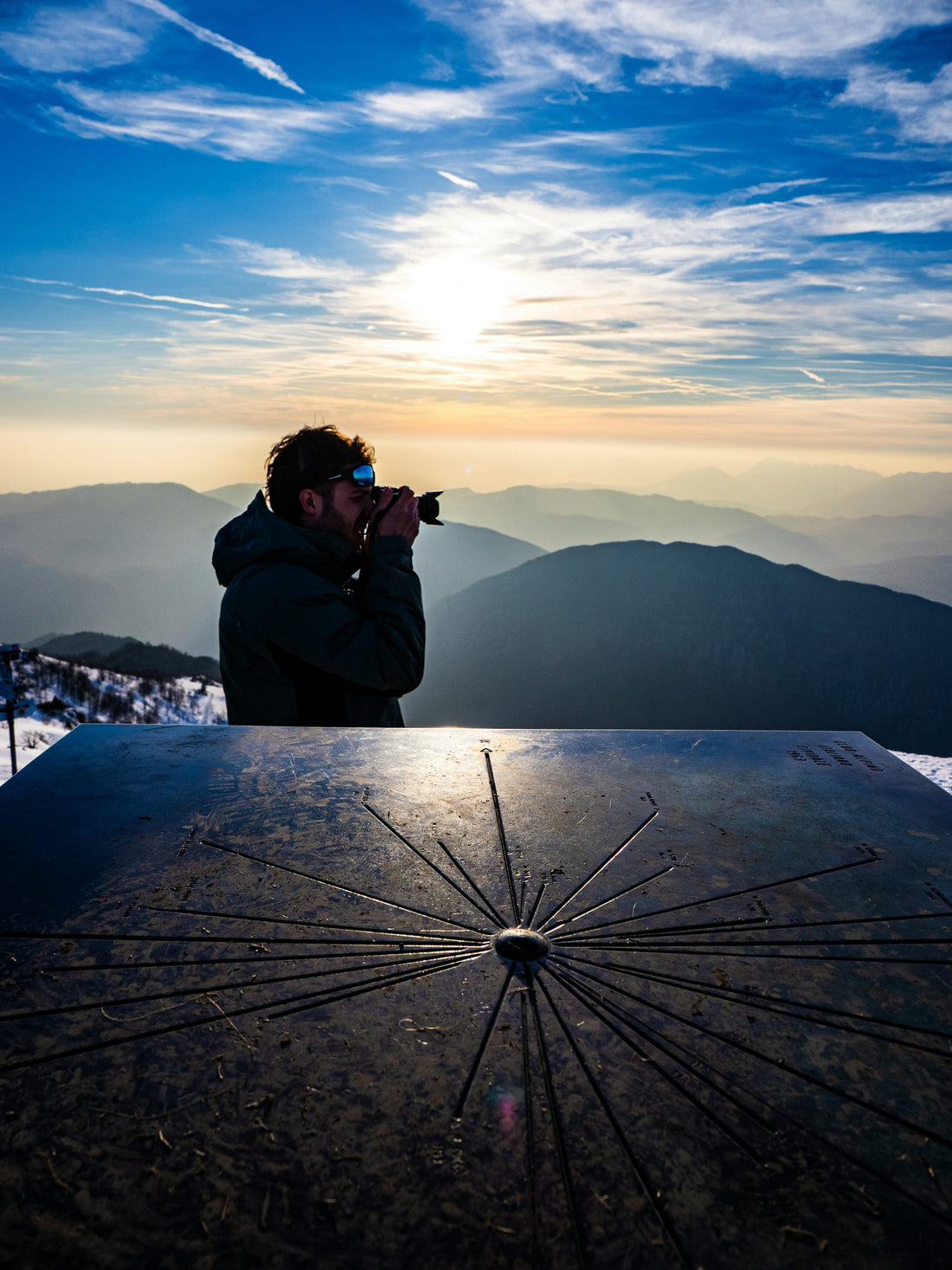 Man drinking coffee on a mountain summit at sunrise, representing a clear-headed start to Dry January 2027
