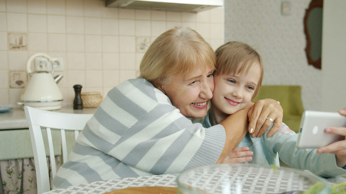 Grandmother and granddaughter taking a smartphone selfie, illustrating family conversations about AI photo boundaries