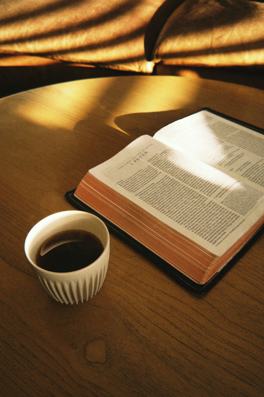 Open Bible and coffee on a sunlit table for a Christian reflection on Scripture, worry, and anxious moments