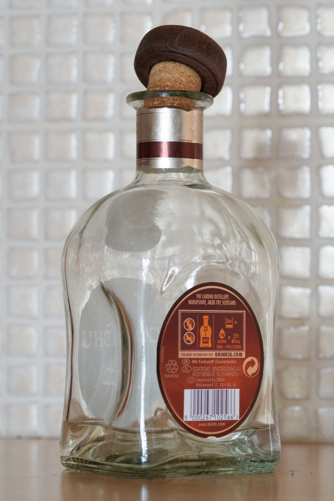 A single whiskey bottle photographed in a restrained editorial style, representing concealed or secret drinking without depicting a specific person.